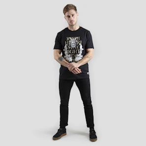 Model wearing a charcoal grey t-shirt with a striking minimalist print standing against a black backdrop