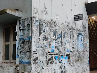 A weathered wall in Brest covered with faded posters and graffiti, capturing urban decay.