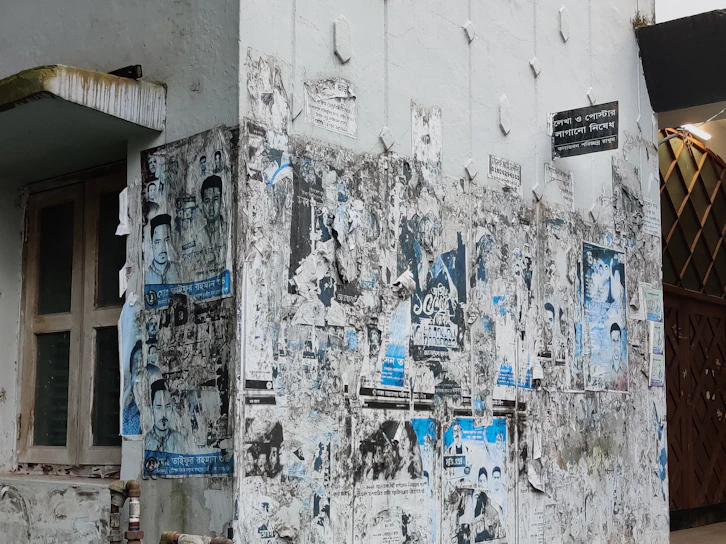 A weathered wall in Brest covered with faded posters and graffiti, capturing urban decay.