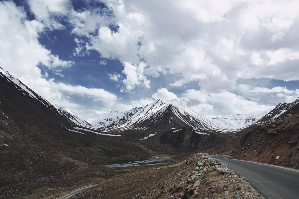 gray and white mountains under white clouds and blue sky during daytime