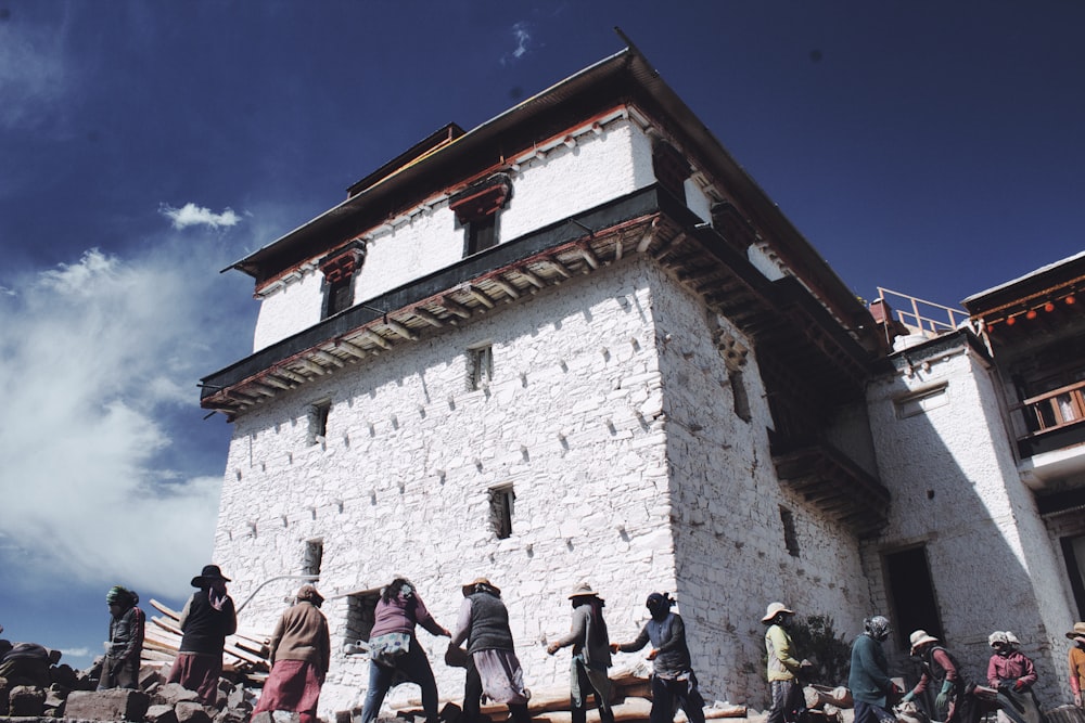 people standing near white concrete building during daytime