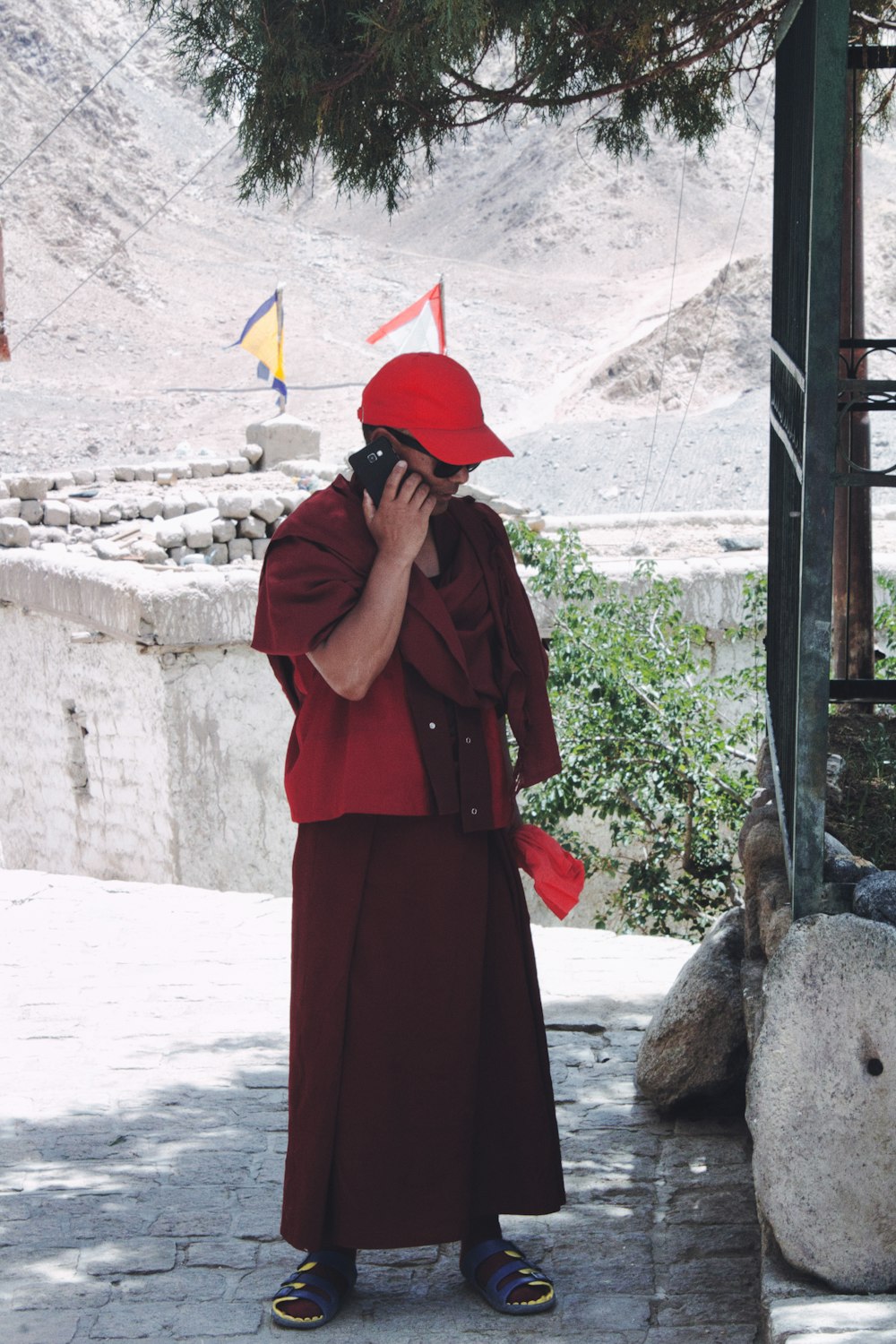 woman in red coat standing near gray concrete wall during daytime