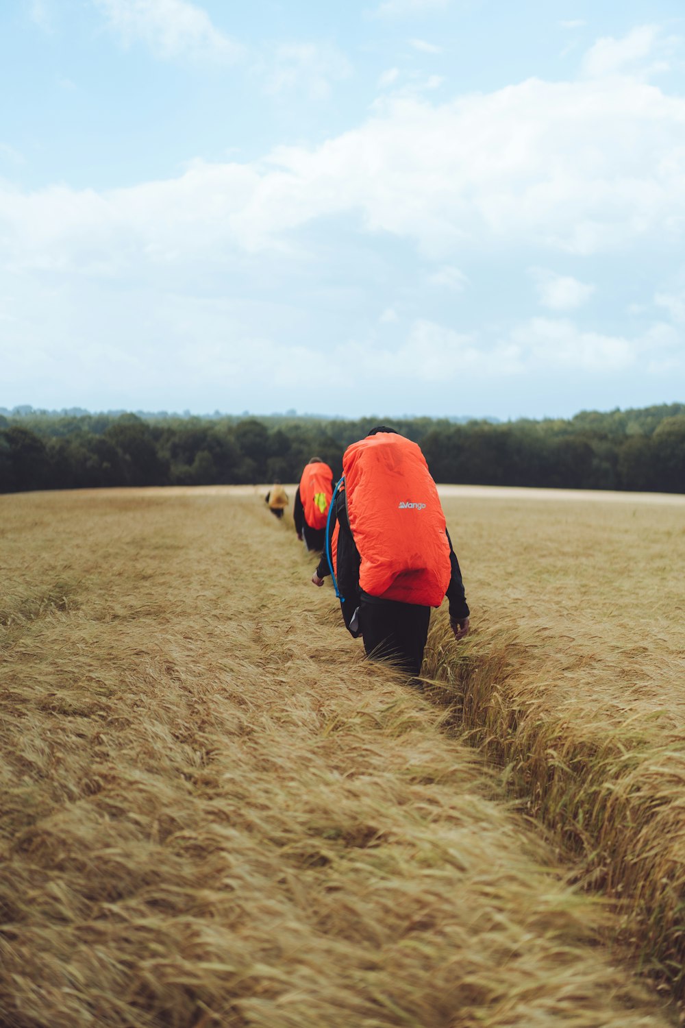 man in red jacket walking on brown grass field during daytime