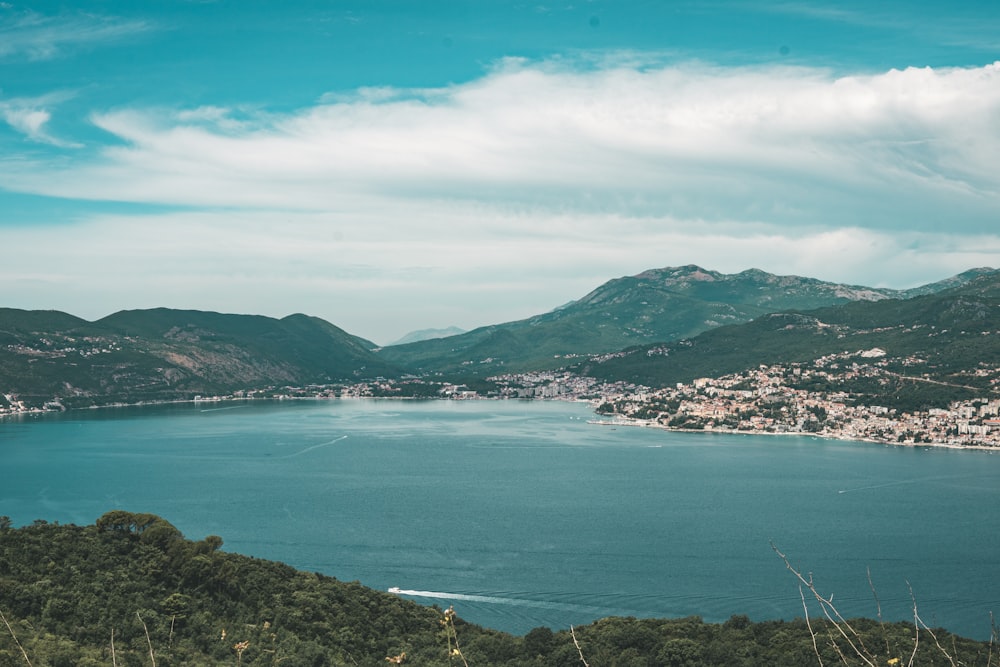 green mountain beside body of water under blue sky during daytime