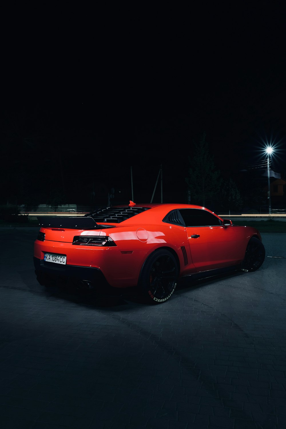 red chevrolet camaro on road during night time