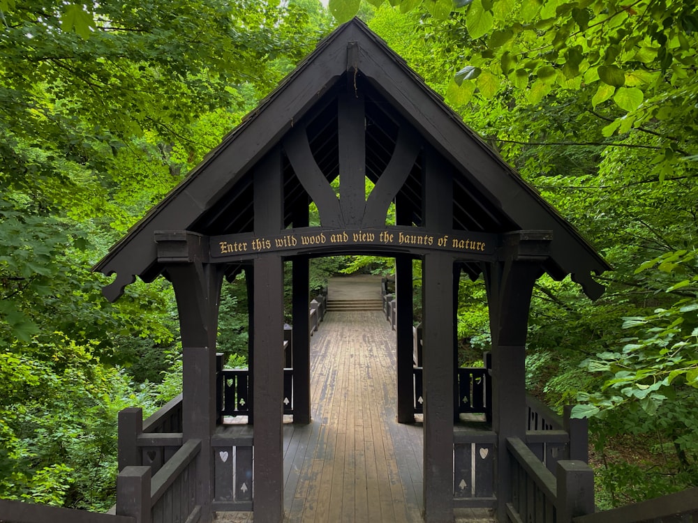 brown wooden gazebo surrounded by green trees during daytime