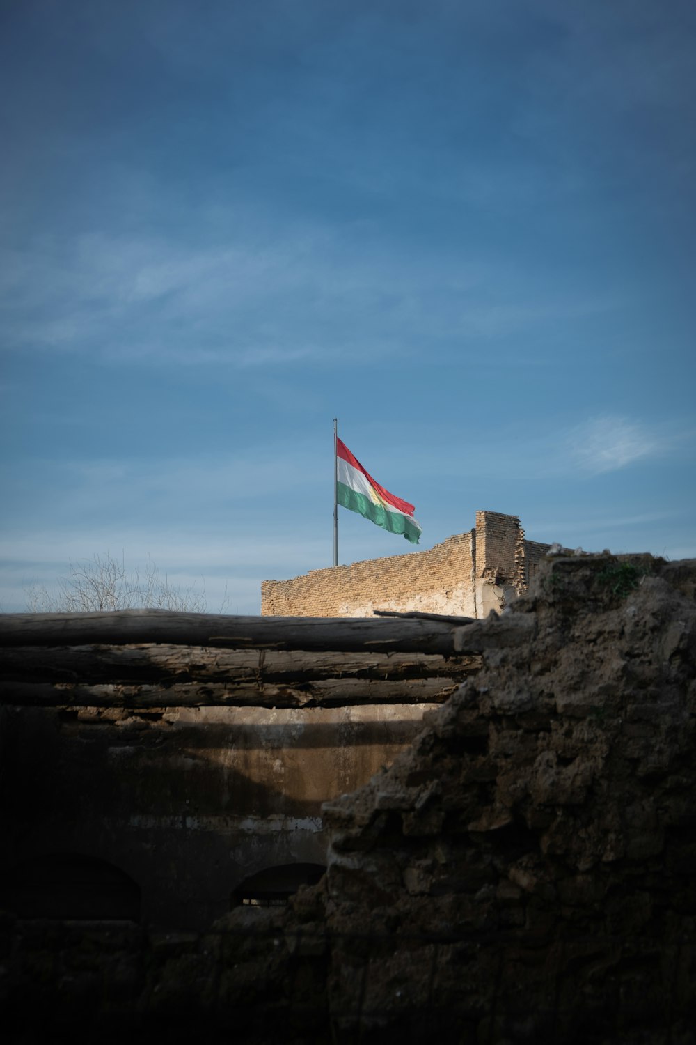 us a flag on brown rock formation near body of water during daytime