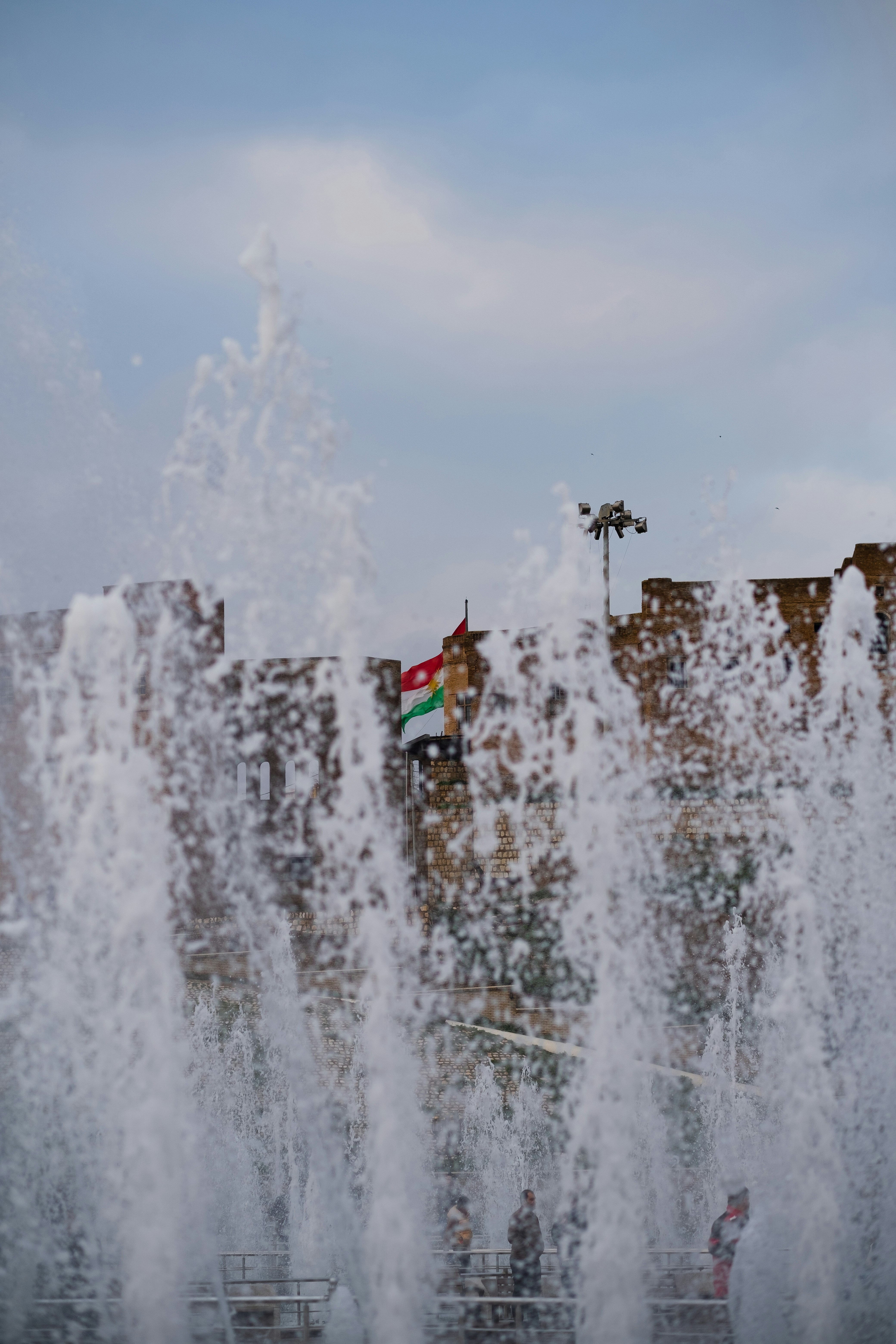 Persone in piedi sull'edificio in cemento marrone durante il giorno