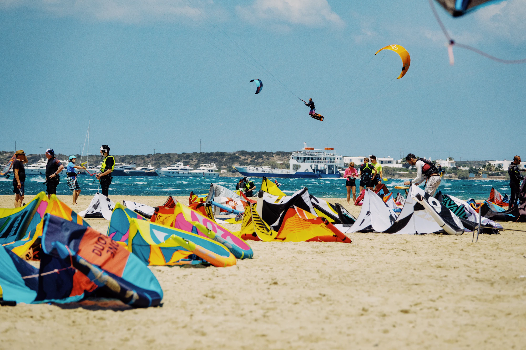 Riders rigging colourful kites on a tropical beach