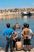 Children playing near a wooden dock by the sparkling water at Diable Camp.
