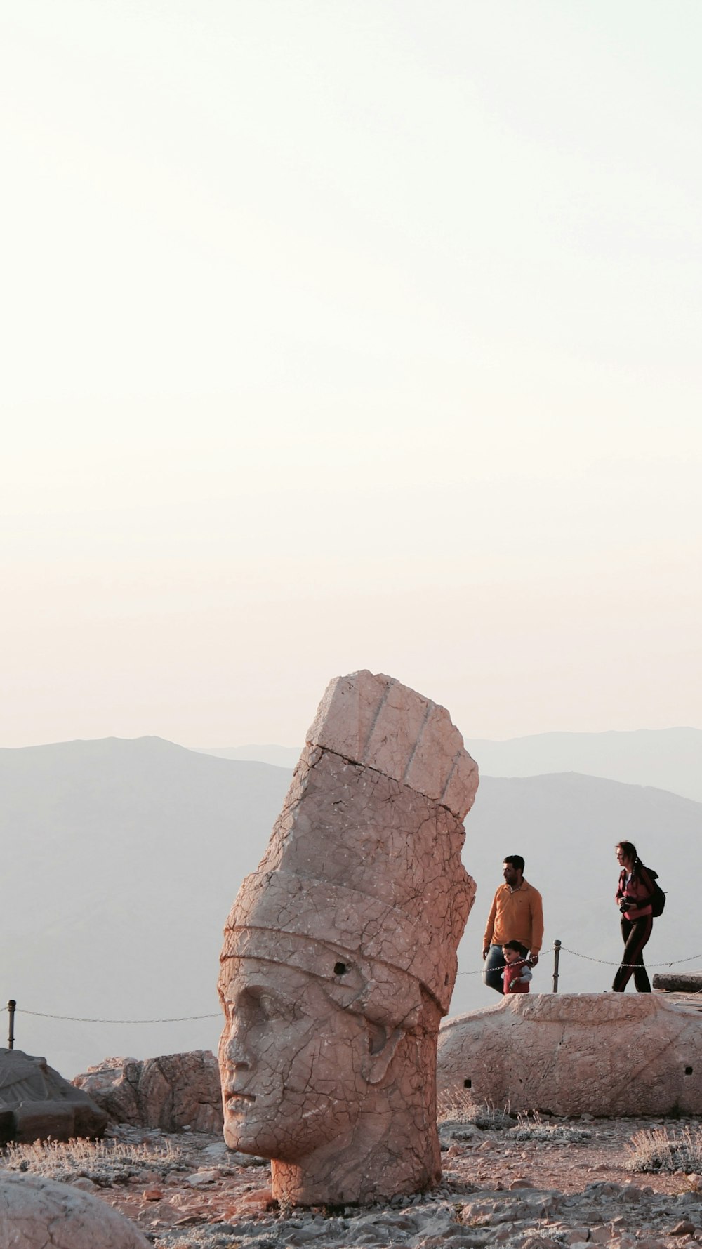 woman in black tank top standing on brown rock formation during daytime