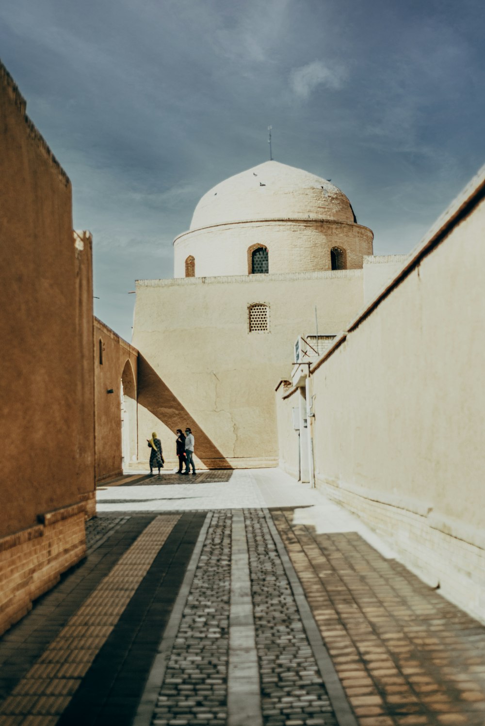 woman in white shirt walking on sidewalk during daytime