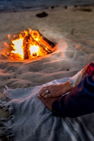 person in blue pants sitting on sand