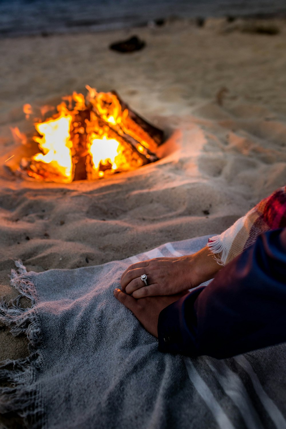 person in blue pants sitting on sand