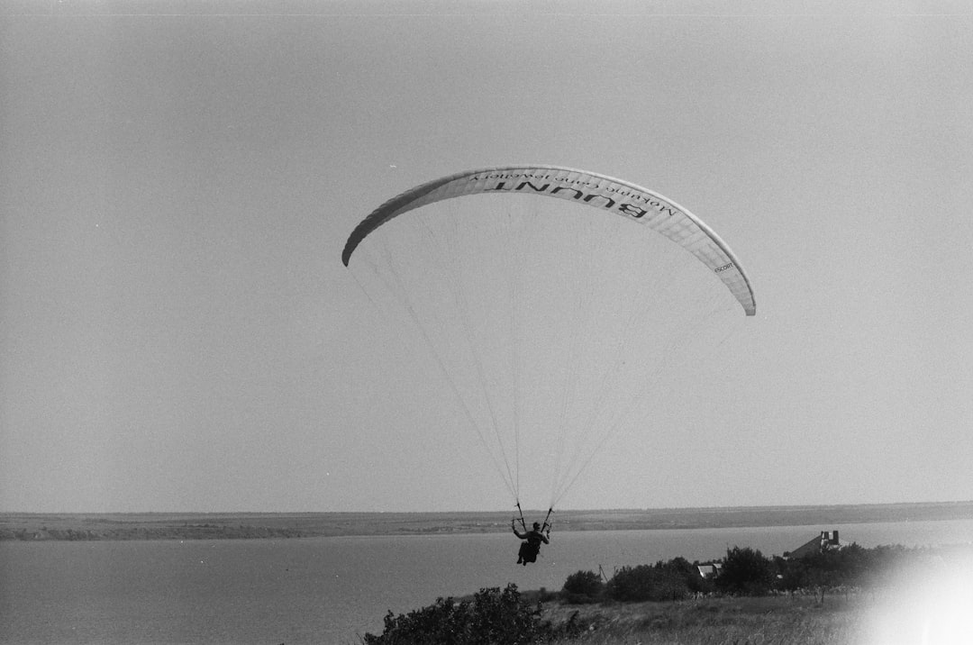 person riding parachute over the sea