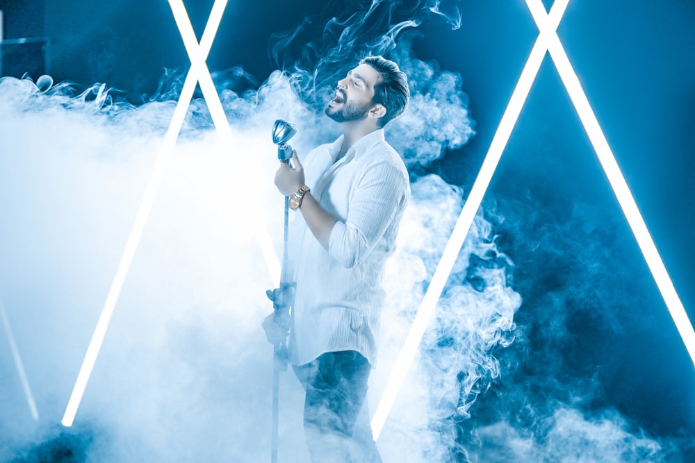 a man standing in smoke holding a microphone