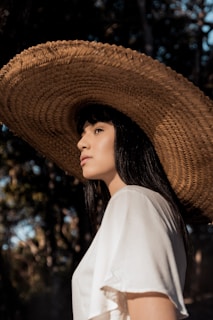 woman in white shirt wearing brown straw hat