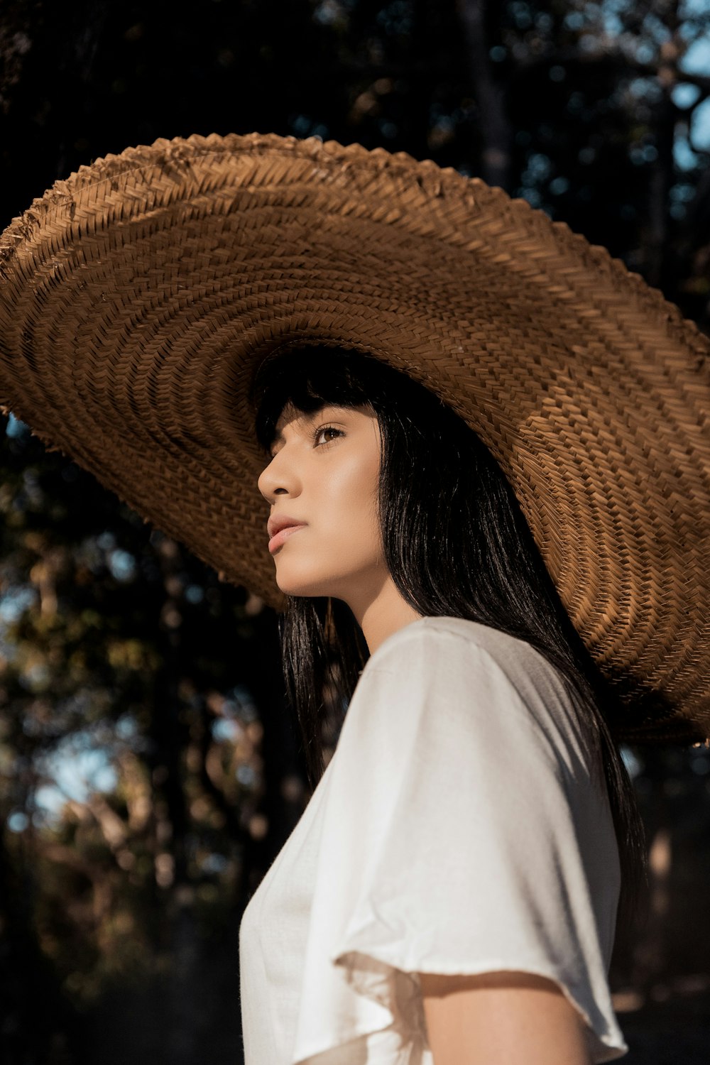 woman in white shirt wearing brown straw hat