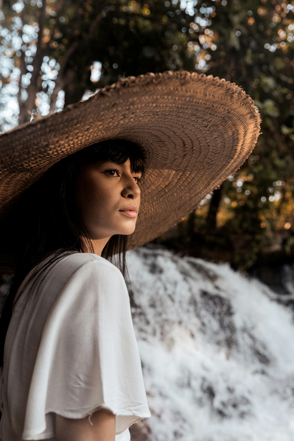 woman in white long sleeve shirt wearing brown straw hat