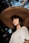 woman in white shirt wearing brown straw hat