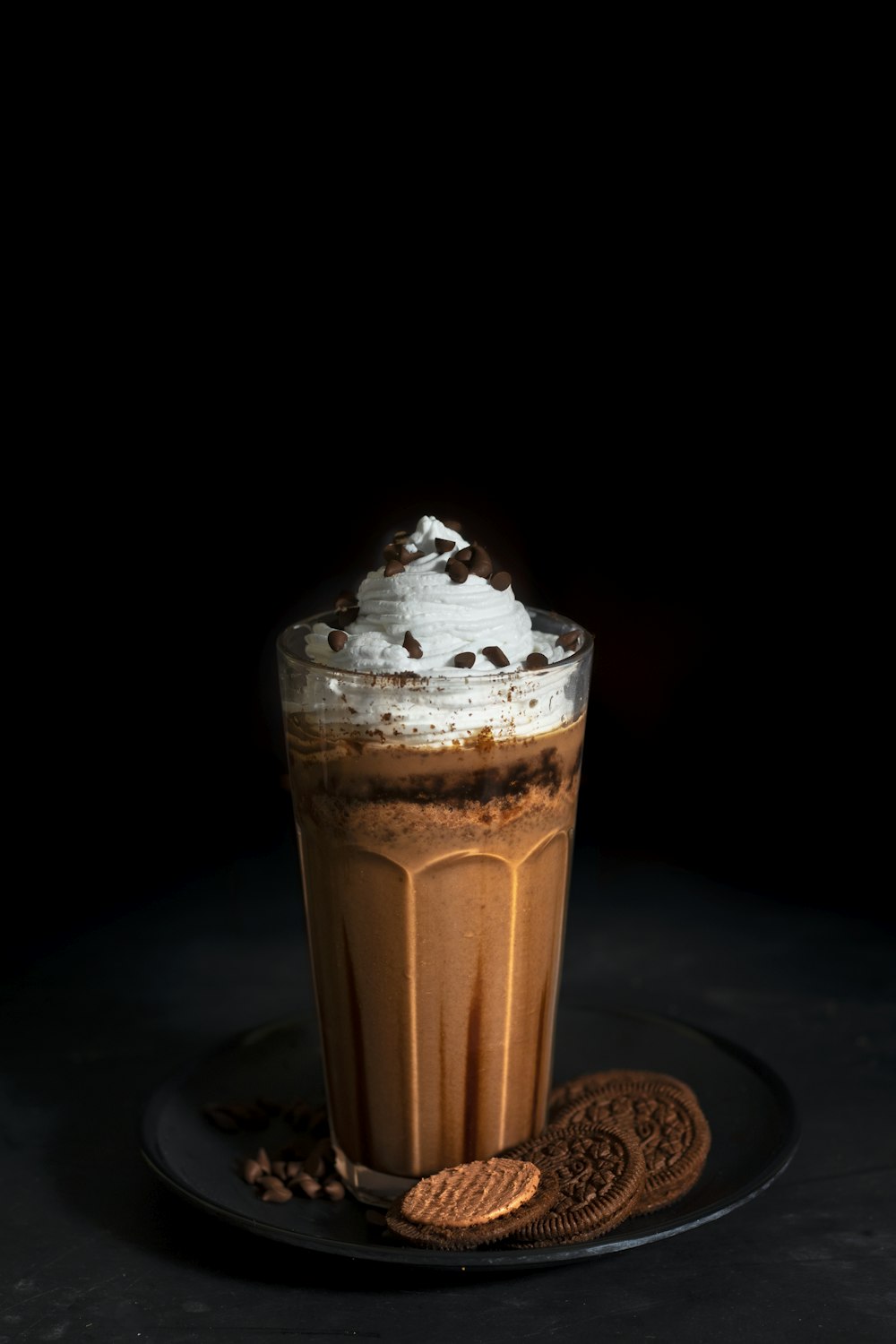 crème glacée brune et blanche dans une tasse en verre transparent