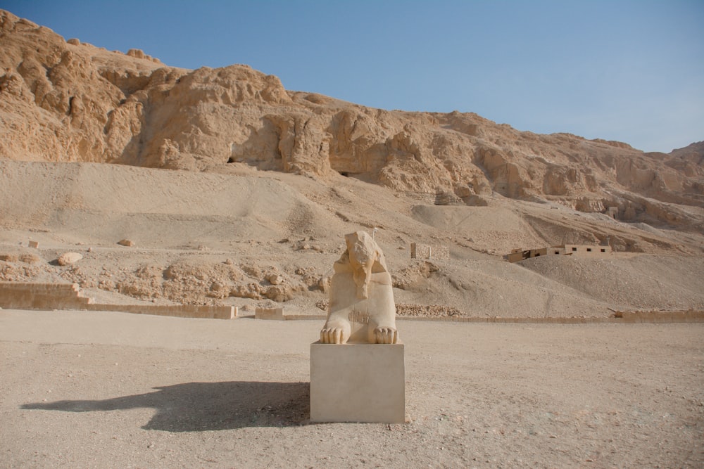 white concrete statue on gray sand during daytime