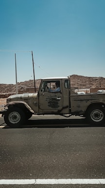 Side profile of a sturdy used pickup truck on a rural road