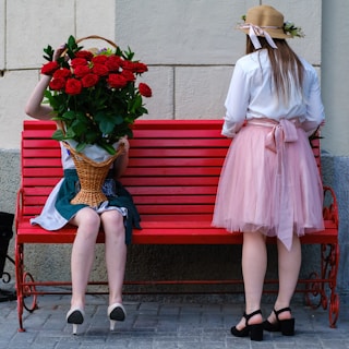 woman in white long sleeve shirt sitting on red bench