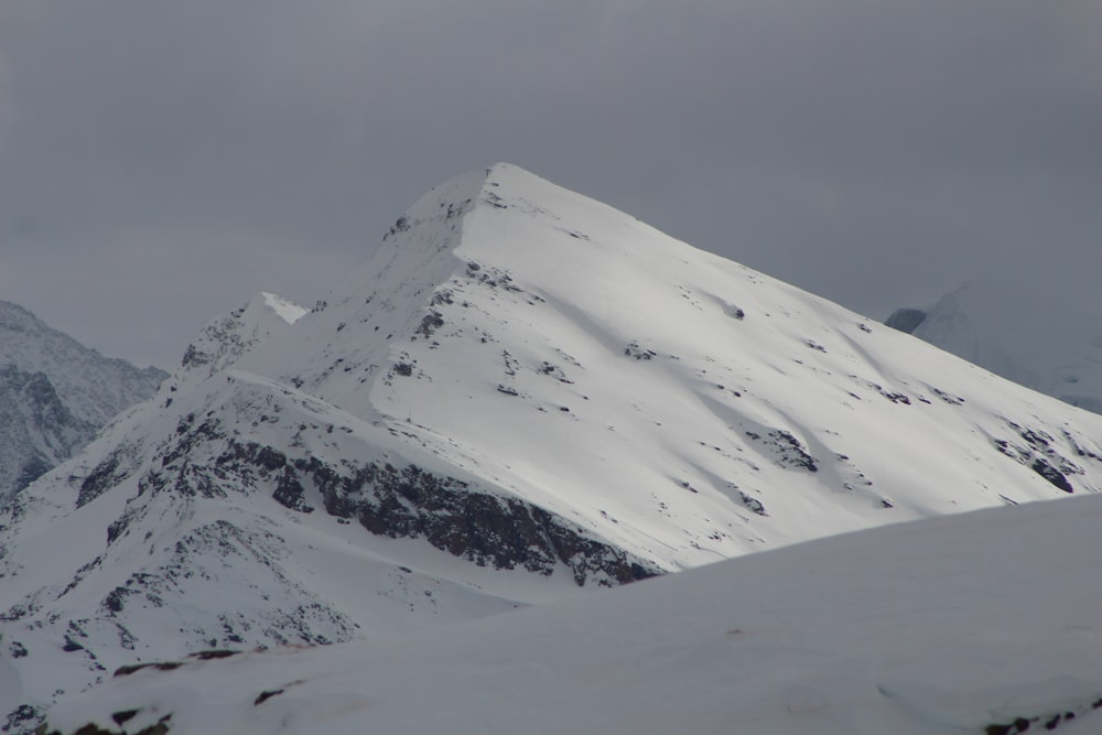 snow covered mountain under gray sky