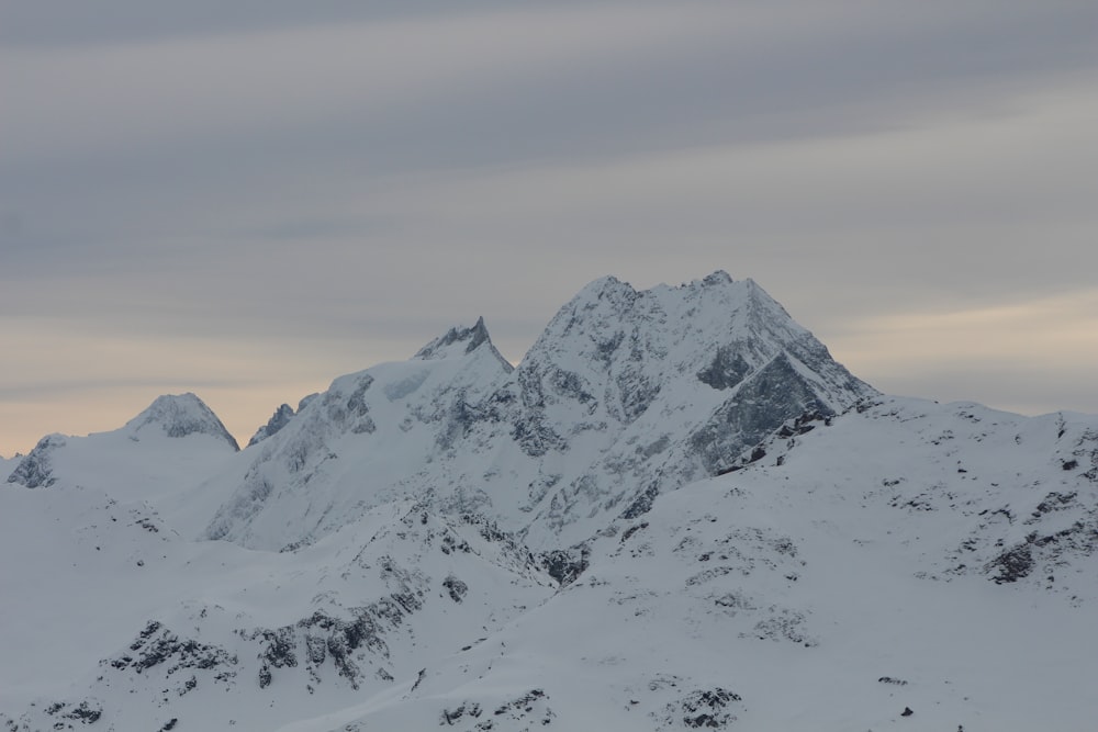 snow covered mountain under cloudy sky during daytime