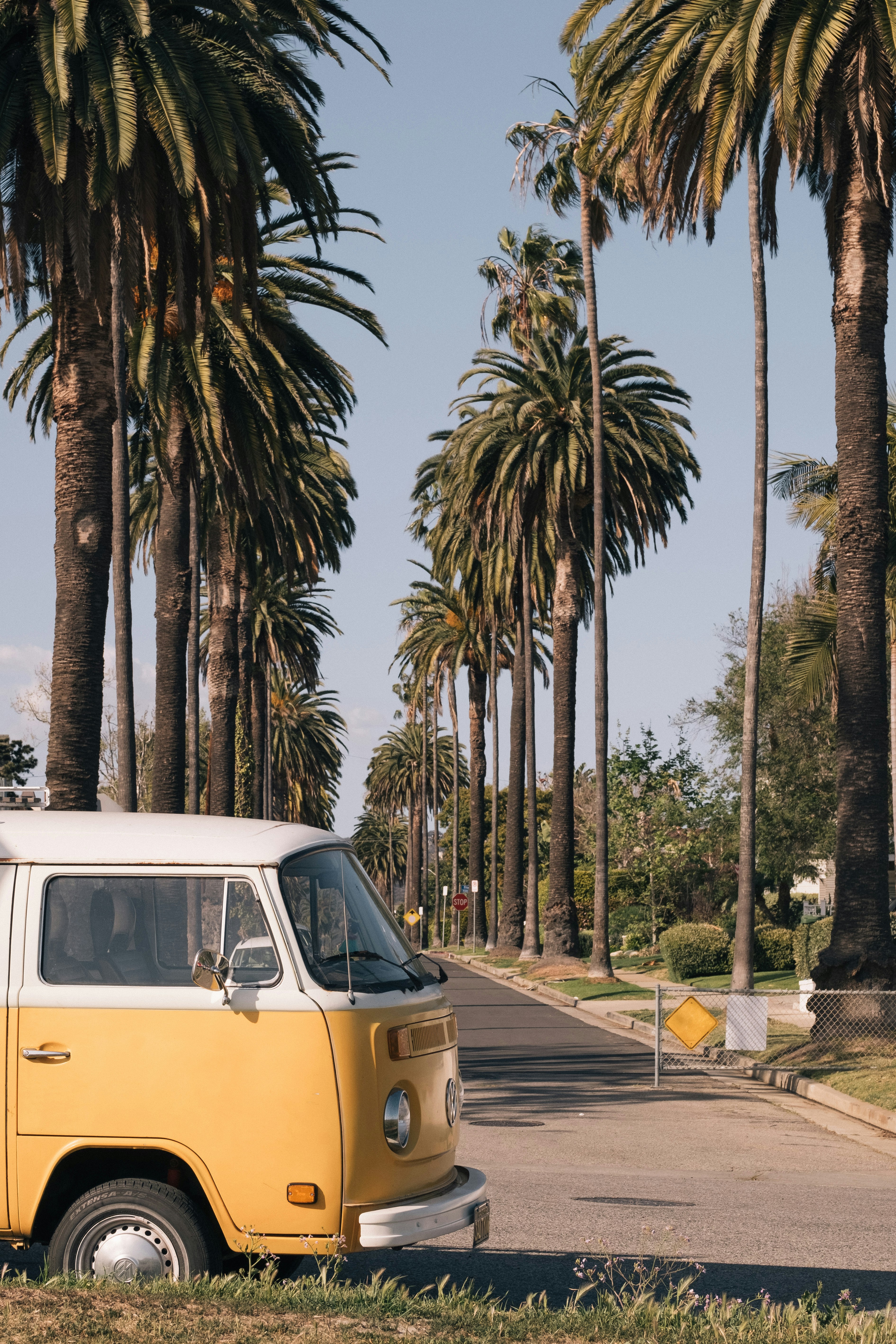 yellow and white volkswagen t-2 parked on sidewalk during daytime