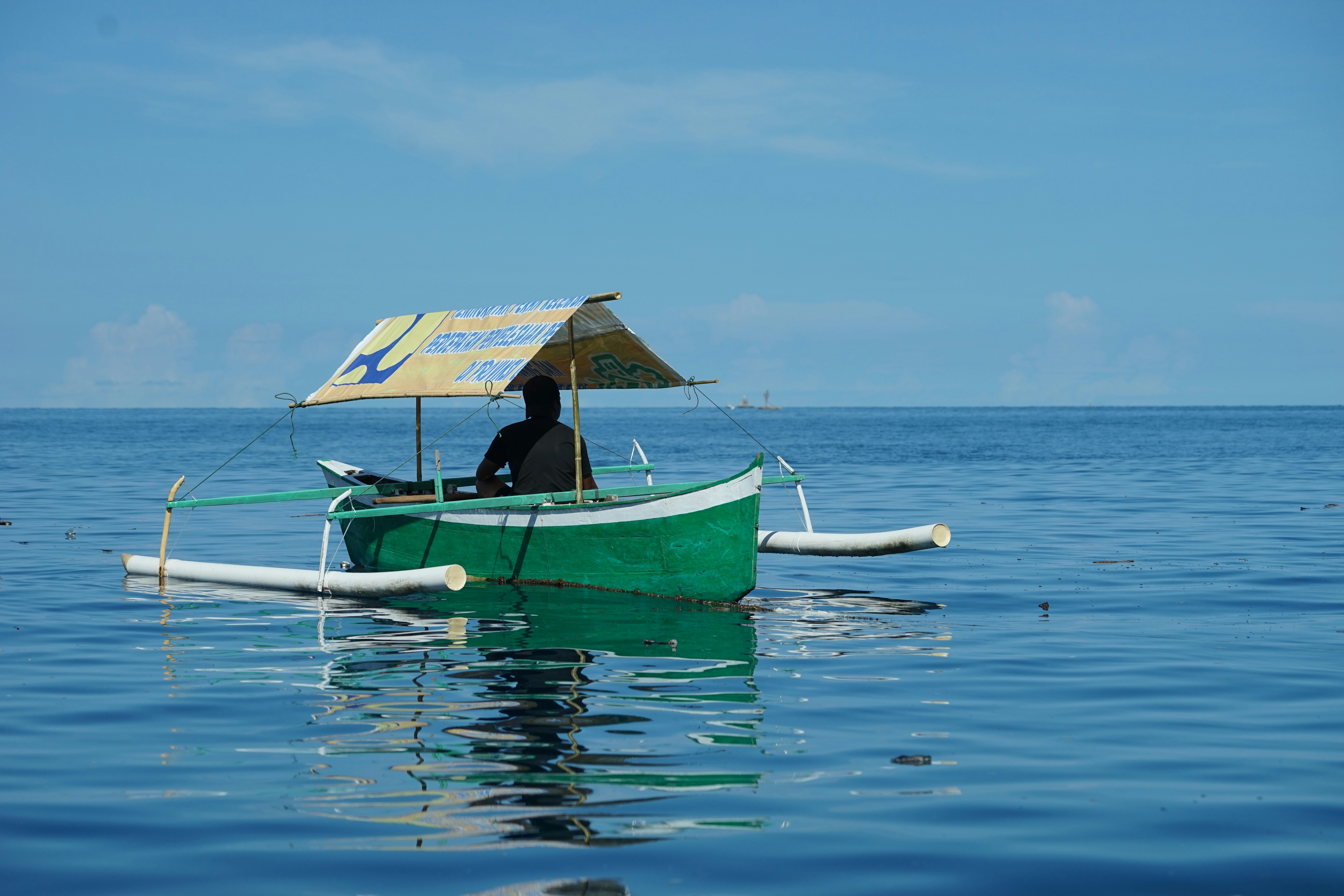 Persona en bote verde en el mar durante el día