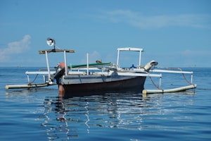 Yamaha outboard motor mounted on a fishing boat cutting through calm blue waters