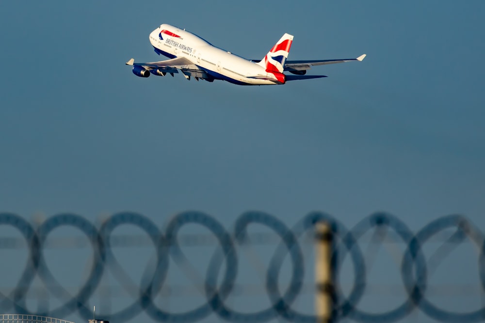 white and red air plane in mid air during daytime