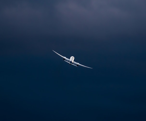 white airplane in mid air during daytime