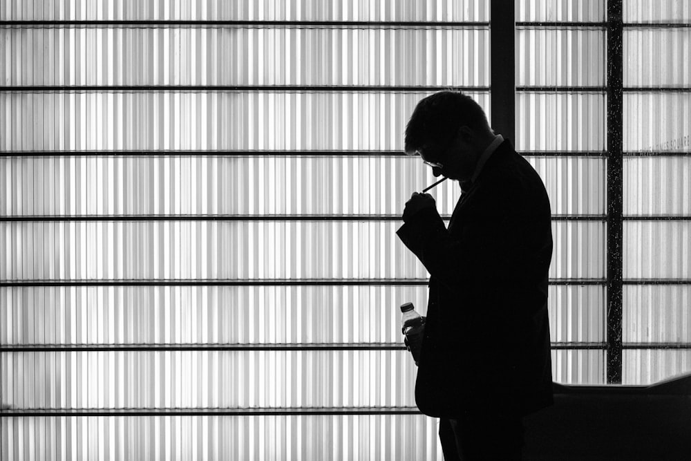 silhouette of man standing near window