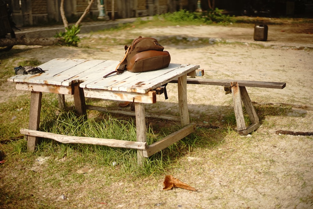 saco de couro marrom na mesa de piquenique de madeira marrom