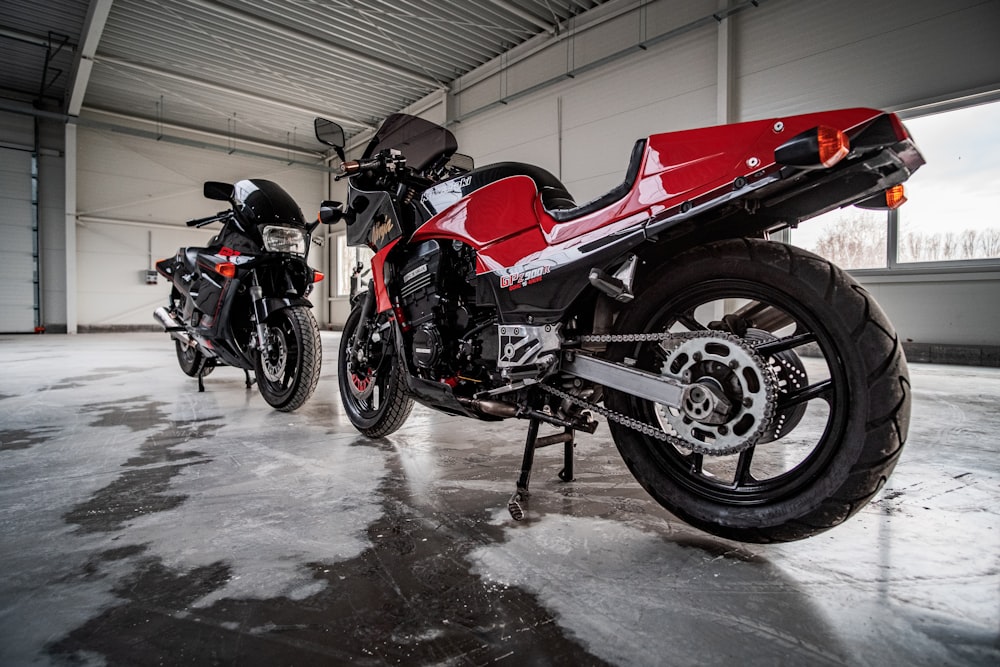 red and black sports bike parked beside red car