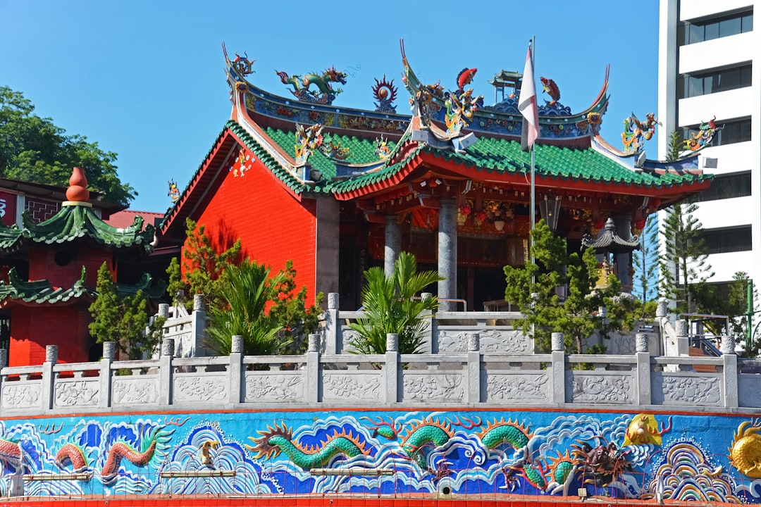 red and white temple with green plants during daytime