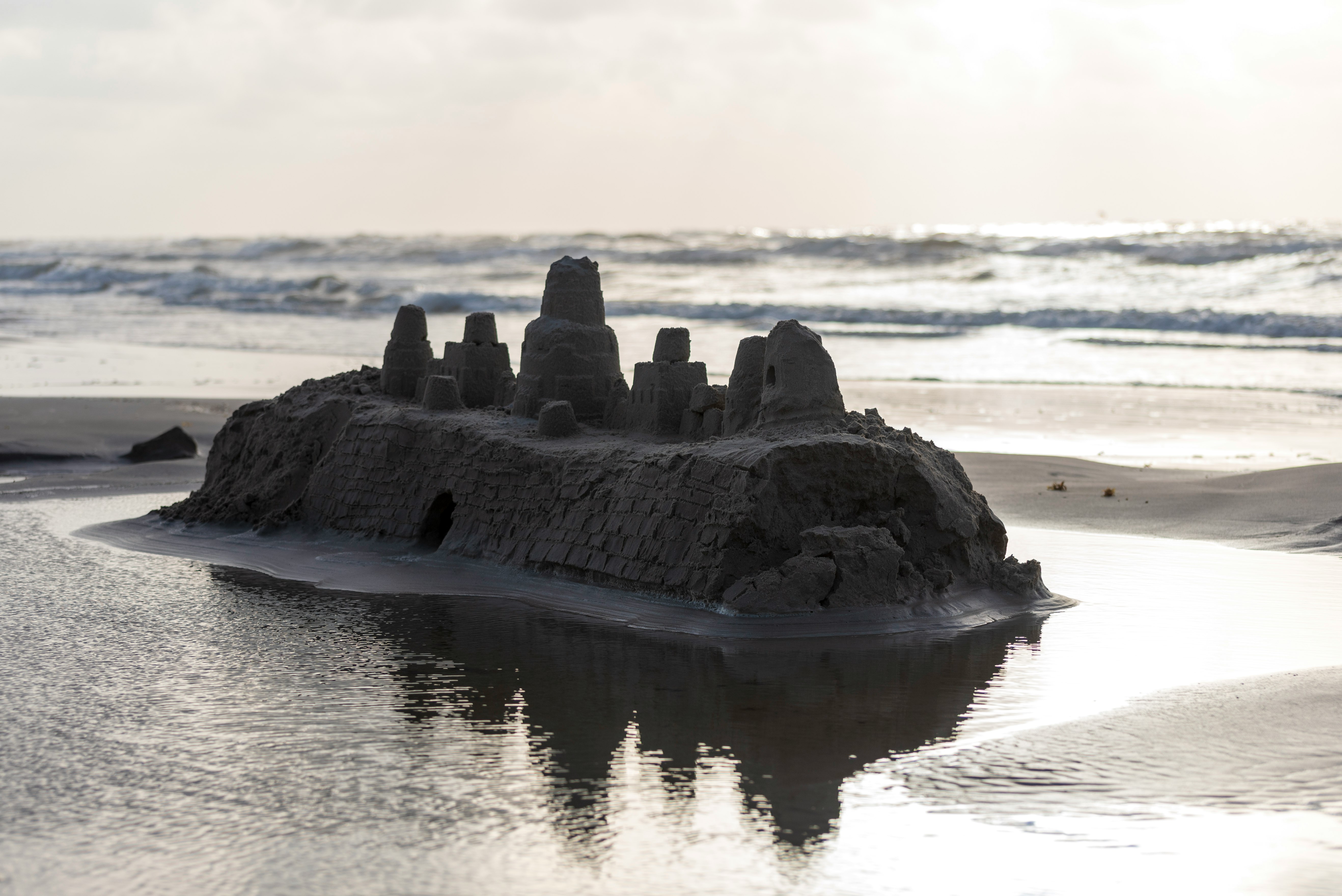 black rock formation on body of water during daytime