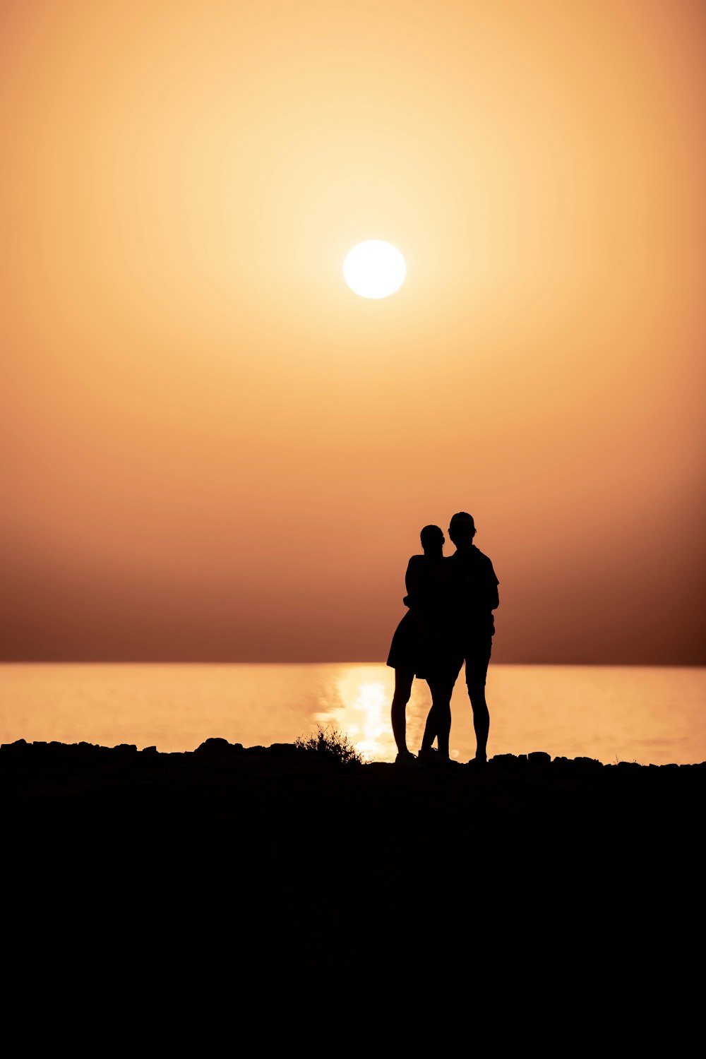 silhouette of man standing on grass field during sunset