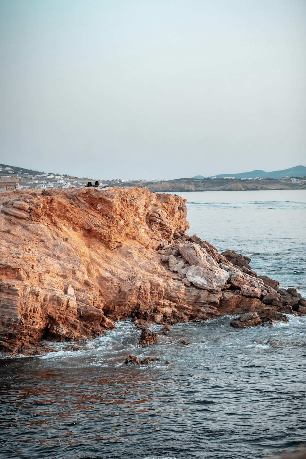 brown rock formation near body of water during daytime