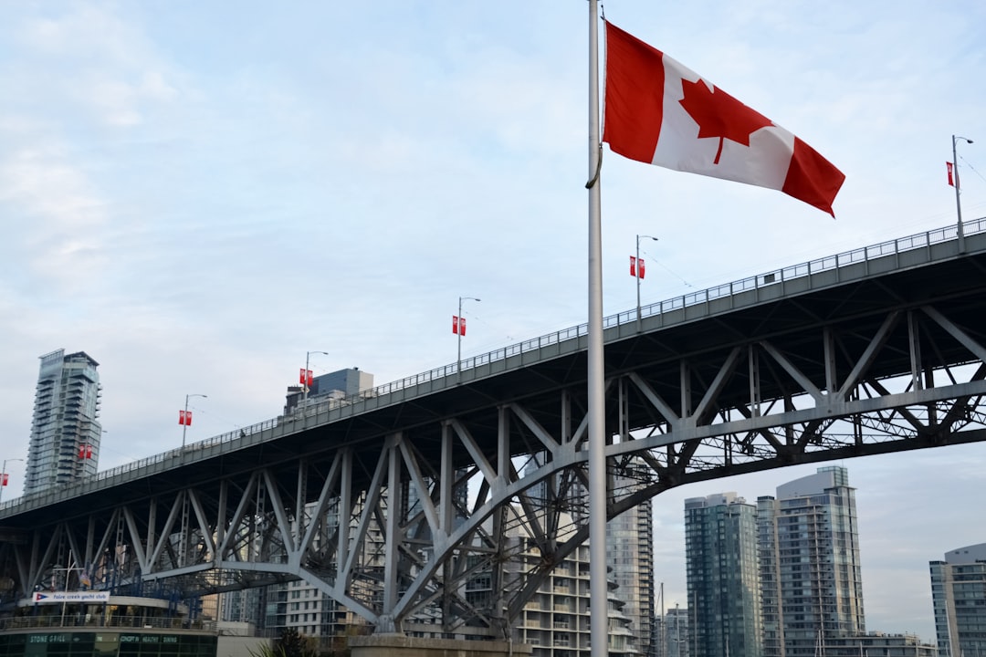 red white flag on top of gray steel bridge during daytime
