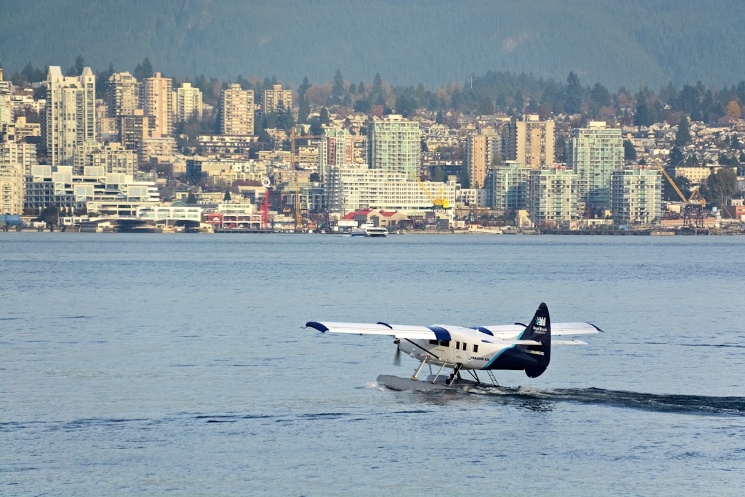 white and black air plane over city buildings during daytime