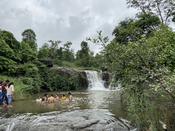 Guests enjoying a refreshing swim in the natural pool surrounded by tropical plants.