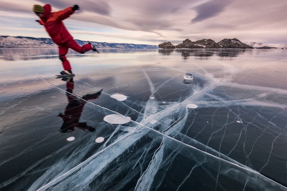 man in red jacket and black pants playing with water