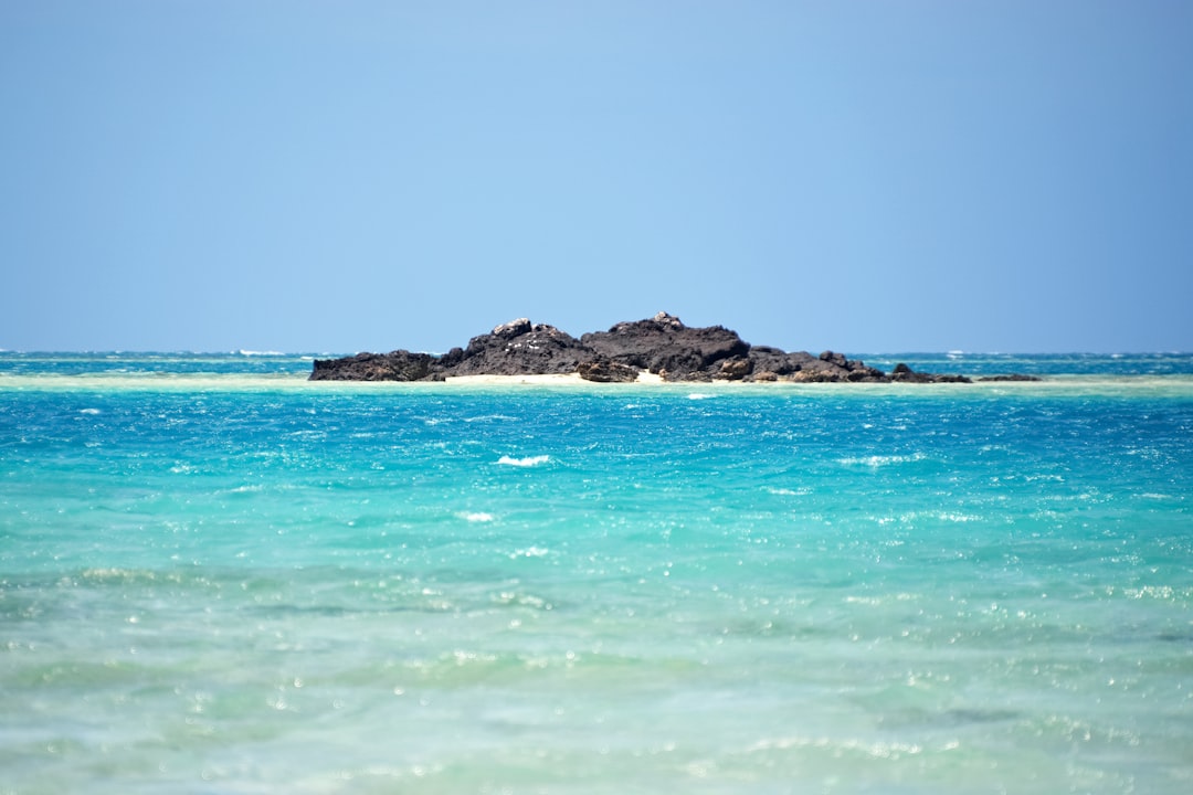 brown rock formation on blue sea under blue sky during daytime