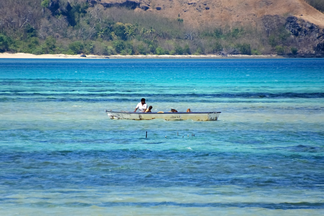 man and woman riding on white boat on blue sea during daytime