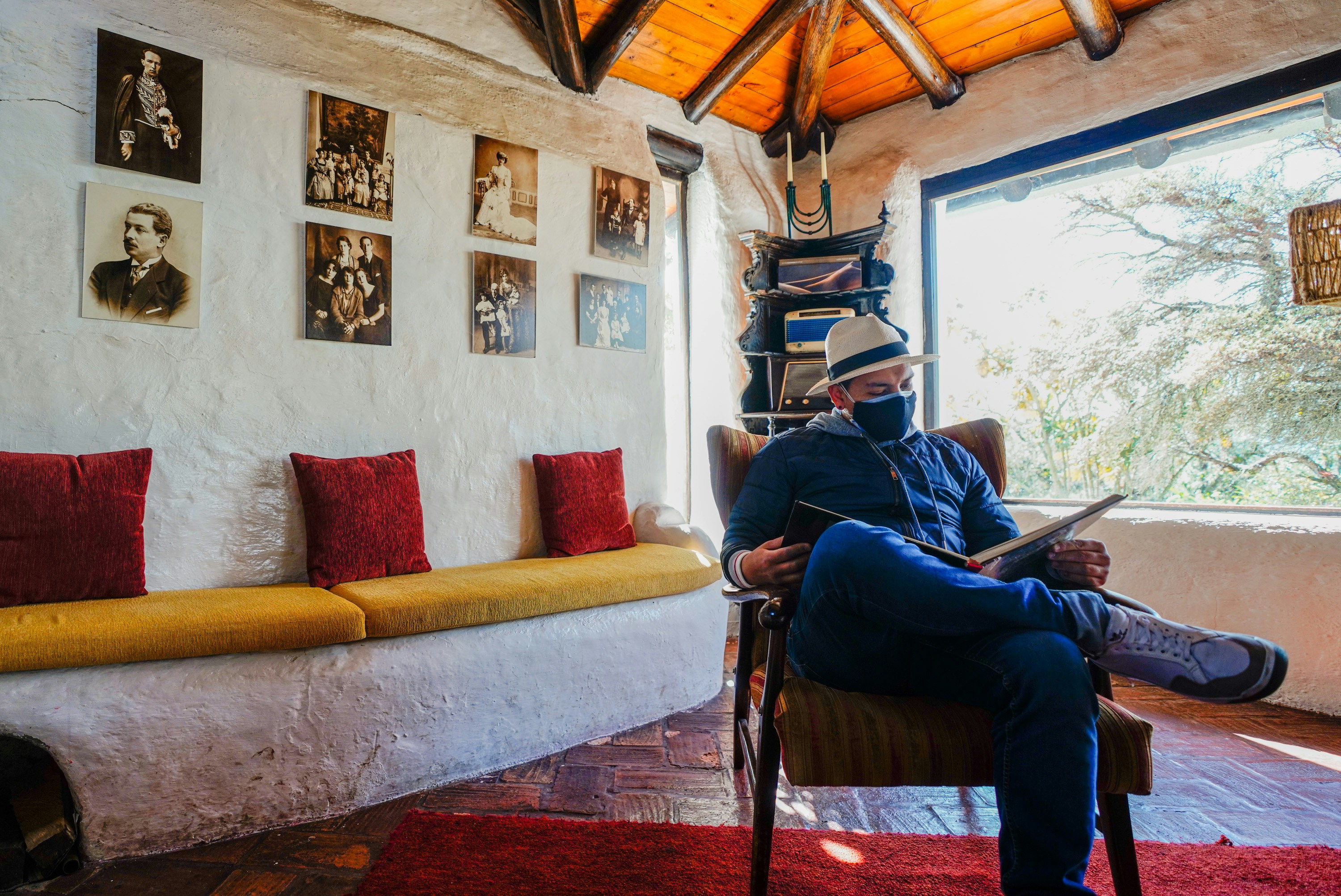 hombre en jeans de mezclilla azul sentado en el sofá rojo