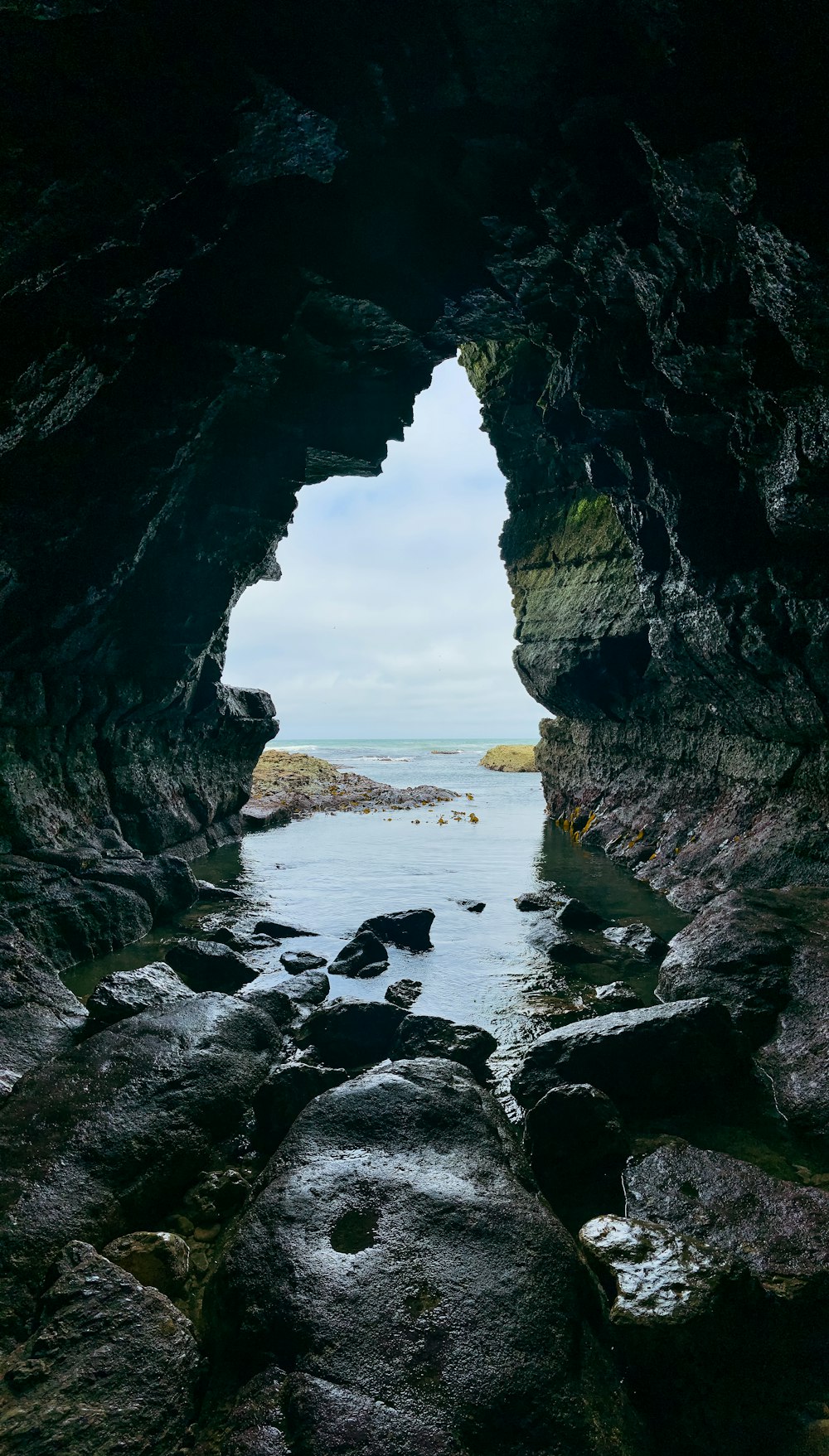 black rock formation near body of water during daytime